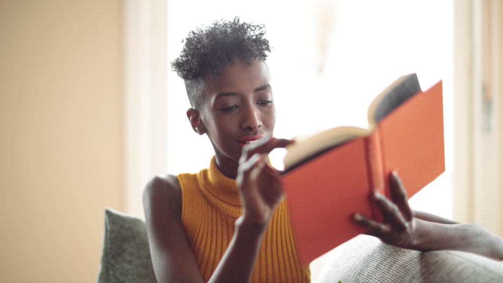 A person immersed in personal development books, searching for their life purpose.